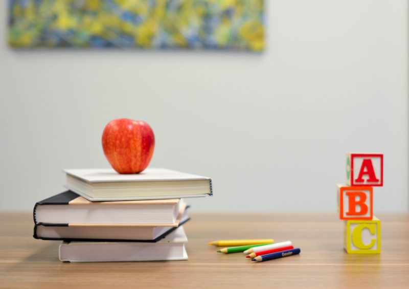 Back to School: apple on top of books with crayons and blocks