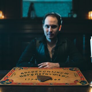 Virtual Seance: Jaymes White in front of Ouiji Board