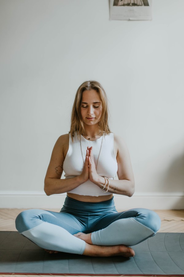 Woman sitting on mat meditating