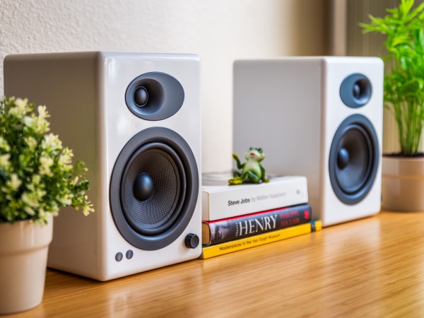 Speakers on table next to books