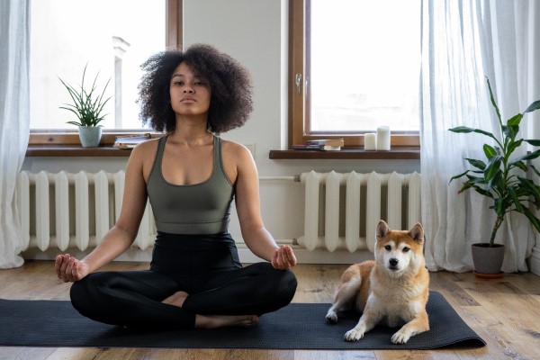 Woman practicing yoga with dog