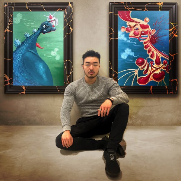 Vancouver Arts and Culture: Russ Wang sitting in front of paintings