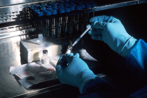 Immunotherapy: Hands in gloves using a dropper into a test tube