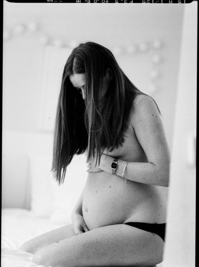 Pregnant woman looking down at her belly