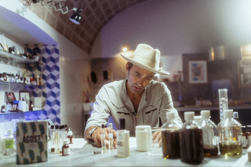 Fragrance Collection: Man sitting at table surrounded by fragrance