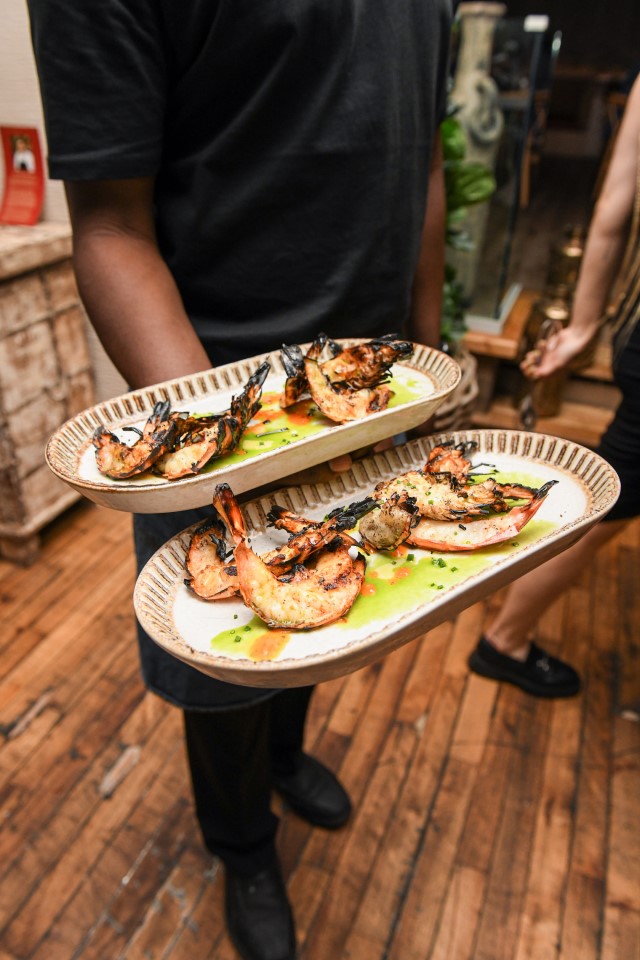 Prawns on two trays held by a server