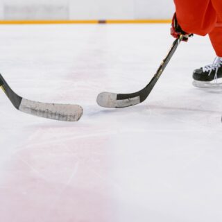 Women's Hockey: Hockey sticks and skates on ice rink