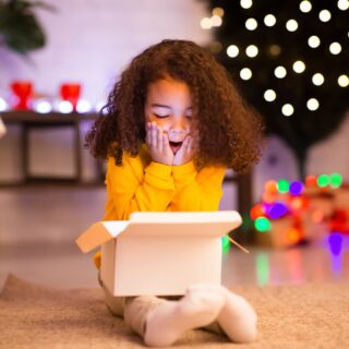 Gift Ideas for Kids: Girl opening Christmas Present