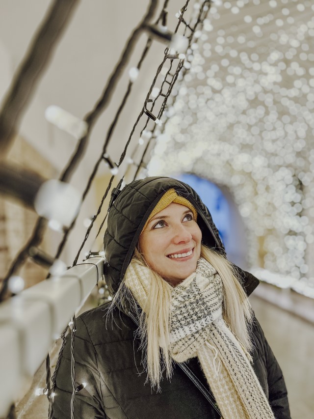 Holiday Photos: Woman standing next to Christmas lights