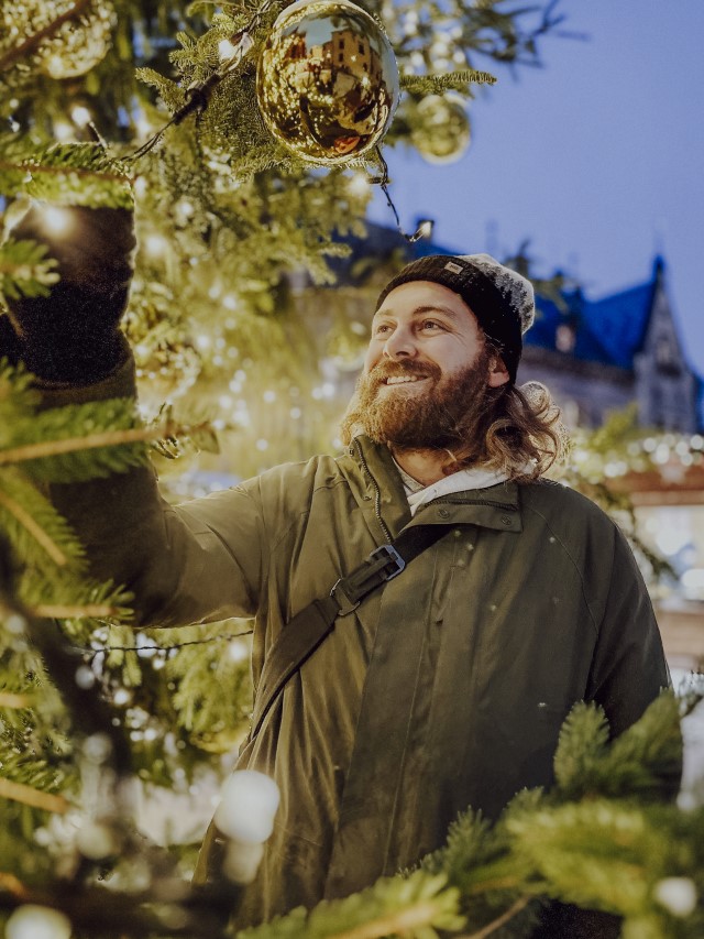 Holiday Photos: Man in front of a Christmas Tree Outdoors