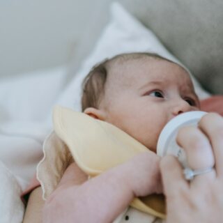 Night Feeds: Faceless mother bottle feeding a baby