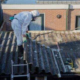 Water Damage: Man working on the roof of a house