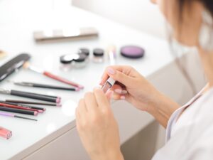 High End Makeup: Woman Applying Lipgloss in front of vanity