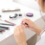 High End Makeup: Woman Applying Lipgloss in front of vanity