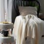 Hygge: Chair with a blanket and candle on a side table