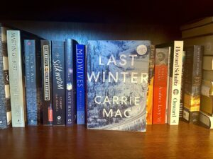 Last Winter: Last Winter on a book shelf with other books spines forward