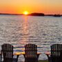 Muskoka: Muskoka chairs facing lake at sunset