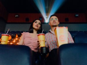 Date Nights: Couple sitting next to each other holding popcorn