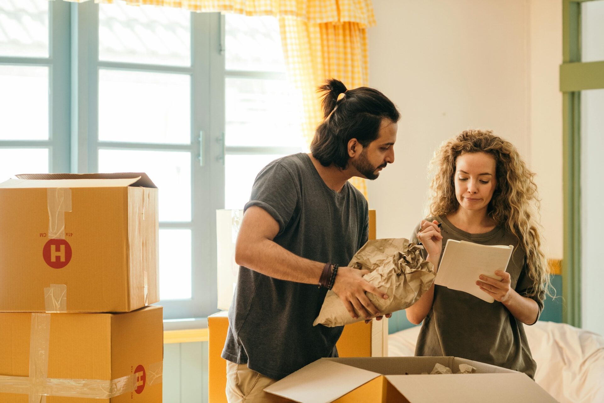 Moving Homes: Happy Couple Surrounded by Moving Boxes