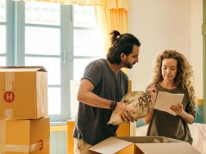 Moving Homes: Happy Couple Surrounded by Moving Boxes