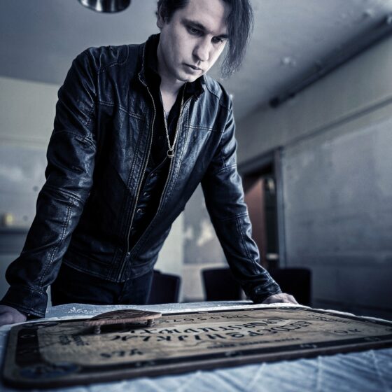 The Art of Mindreading: Jaymes White standing over a ouija board