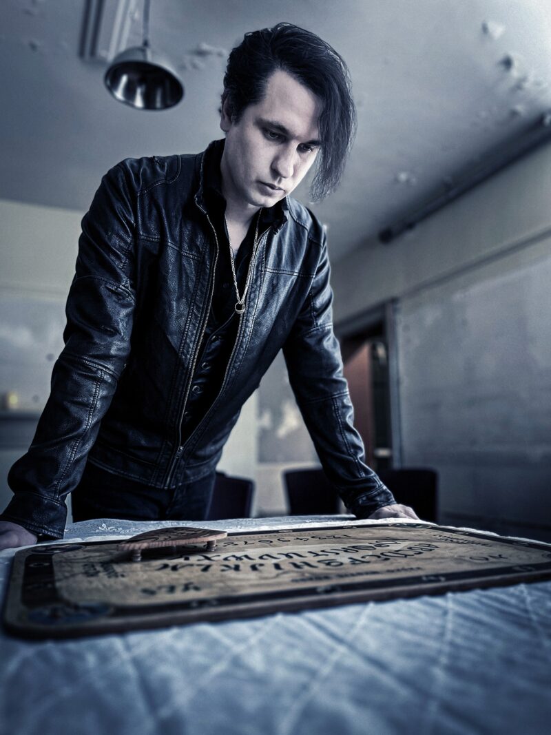 The Art of Mindreading: Jaymes White standing over a ouija board
