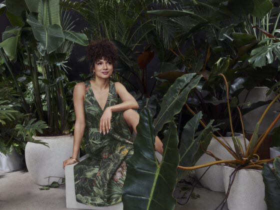 Toni Fifi x Reitmans: Toni Fifi sitting down in a green printed dress among greenery