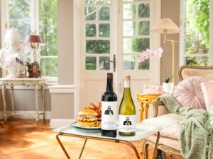 Woman Dinner: Living room with two bottles of wine and a burger on a TV tray