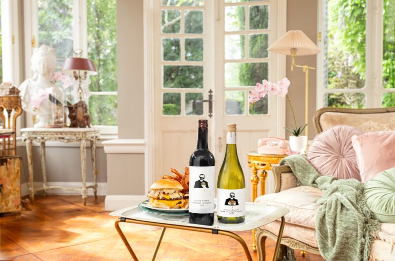 Woman Dinner: Living room with two bottles of wine and a burger on a TV tray