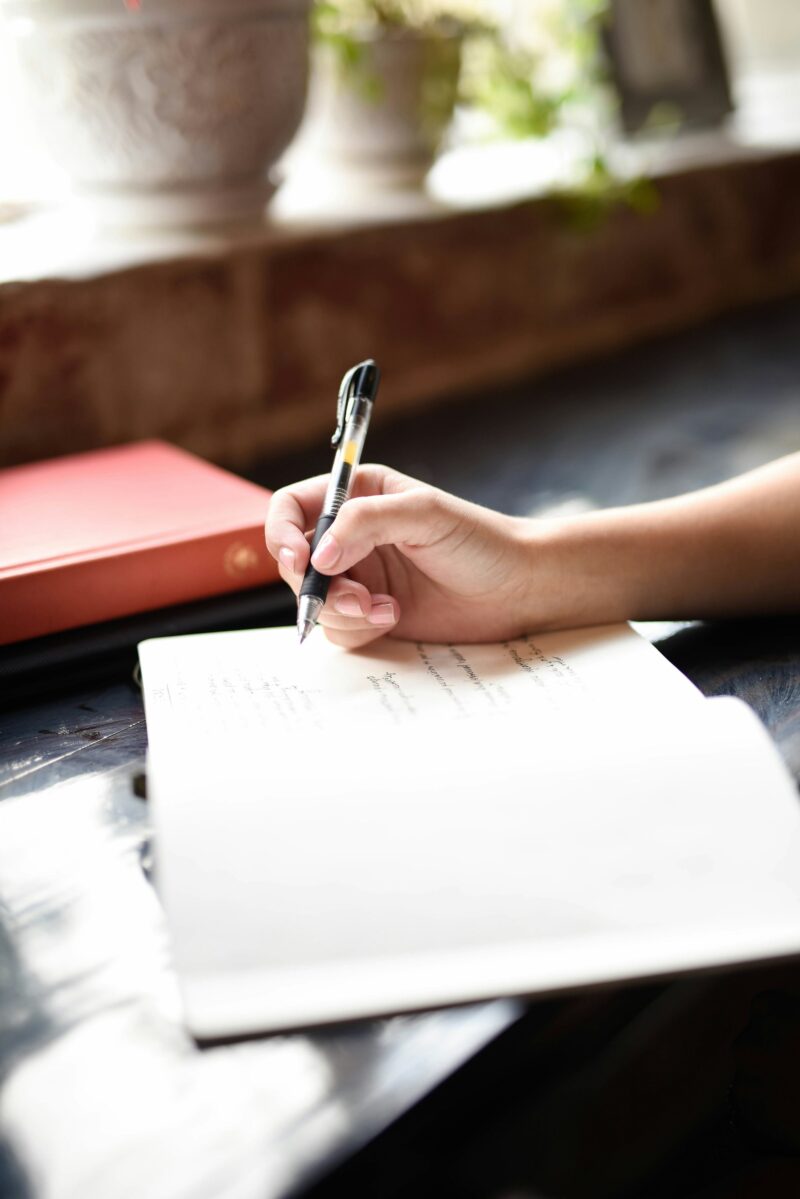 Journaling: A woman's hand holding a pen writing in a journal