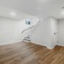 Basement Waterproofing: Empty basement area with hardword floors and a staircase