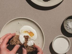 Banana Bread: Woman's hands spreading creme fraiche on bread