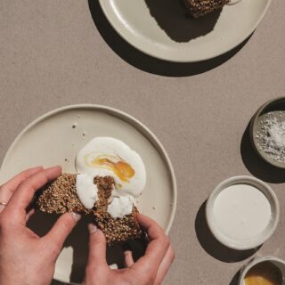 Banana Bread: Woman's hands spreading creme fraiche on bread