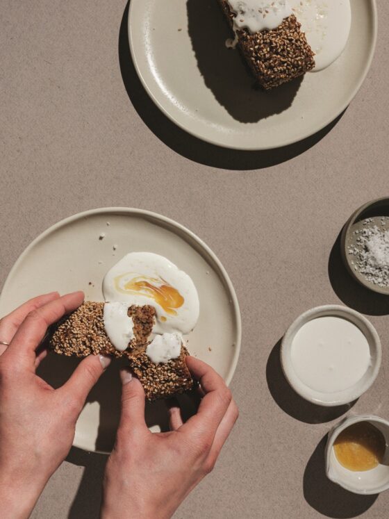 Banana Bread: Woman's hands spreading creme fraiche on bread