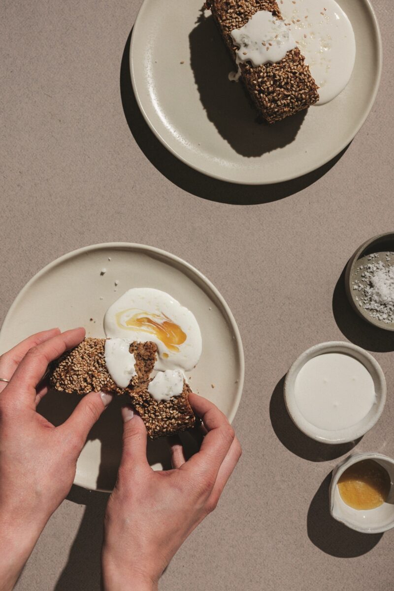 Banana Bread: Woman's hands spreading creme fraiche on bread