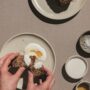 Banana Bread: Woman's hands spreading creme fraiche on bread