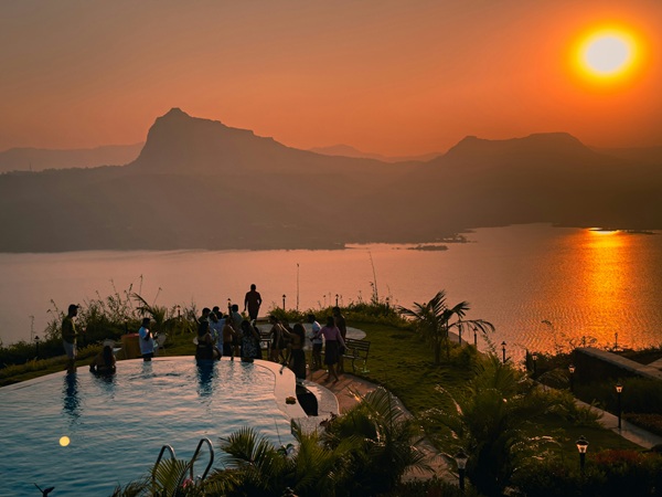 Sundowner: a group of people standing around a swimming pool