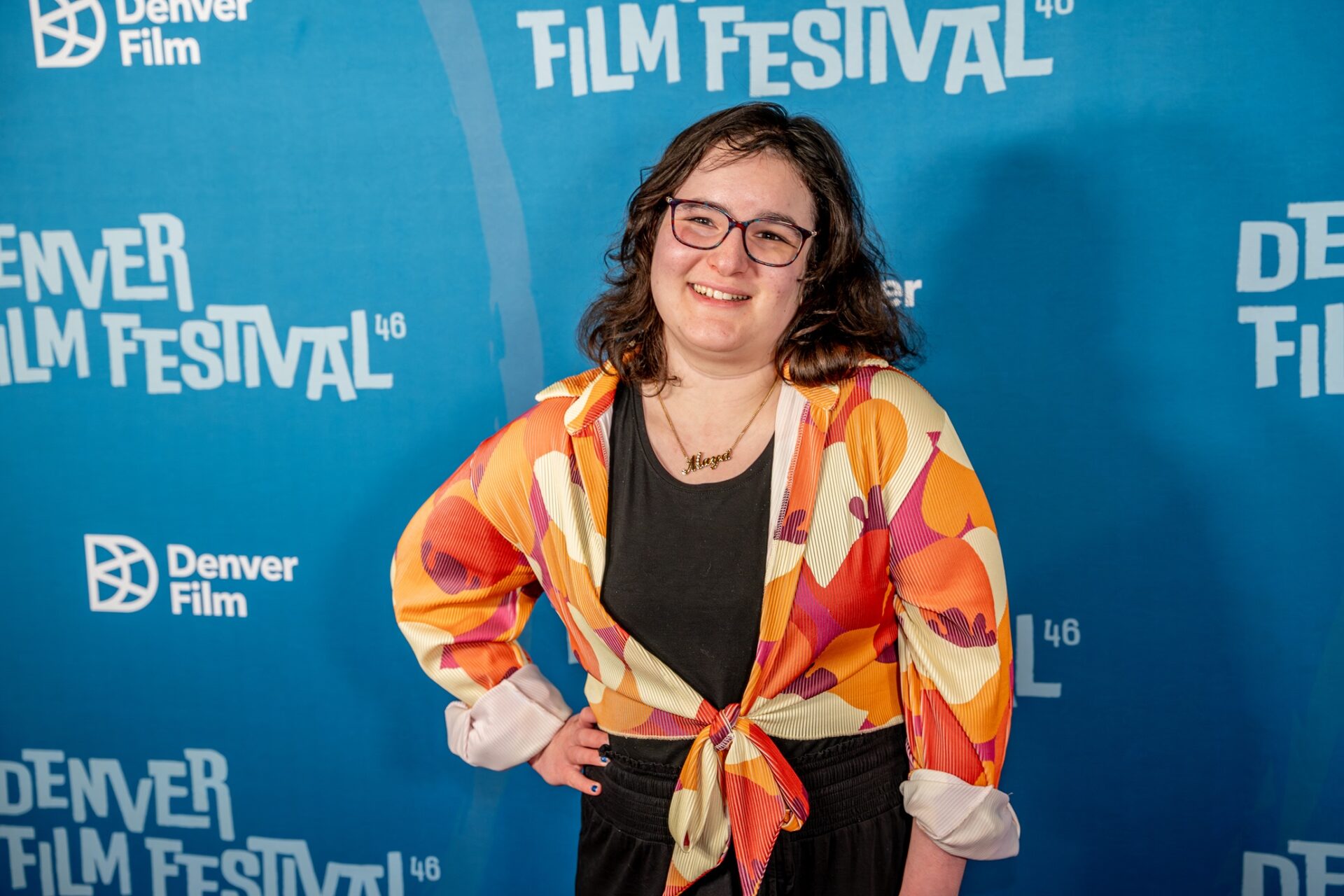 The Latest With Maya: Maya Abrahamsson in front of a step and repeat