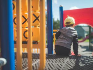 Jungle Gym: Little boy sitting on a jungle gym in close up shot