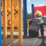 Jungle Gym: Little boy sitting on a jungle gym in close up shot