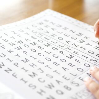 Wordsearch: Close up of a hand working on a wordsearch