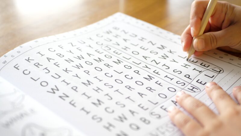 Wordsearch: Close up of a hand working on a wordsearch