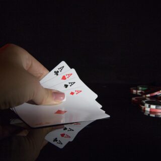The Casino: Woman's hand with 4 aces and poker chips nearby