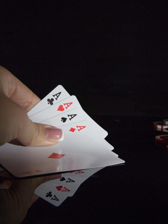 The Casino: Woman's hand with 4 aces and poker chips nearby