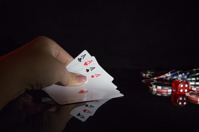 The Casino: Woman's hand with 4 aces and poker chips nearby