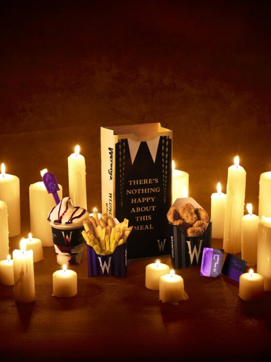 Meal of Misfortune: Wendy's x Wednesday full meal including chicken nuggets, fries, Frosty and themed paper bag amongst candles