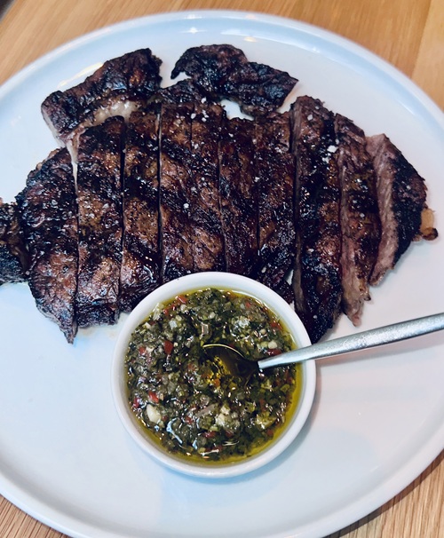 Abrielle: Prime Ribeye well-done with sauce in a small bowl