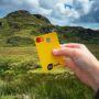 eq bank card: Woman's hand holding an EQ Bank Card in front of a hill
