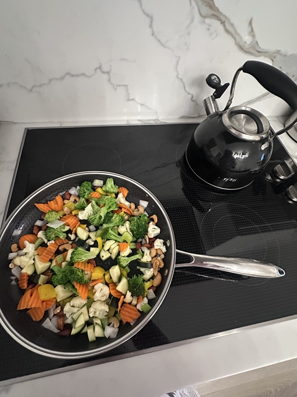 Hexclad: Frying pan on a ceramic stove top with kettle in the background