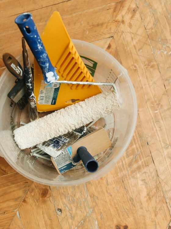 Restoration experts: tools in a bucket on a wooden floor